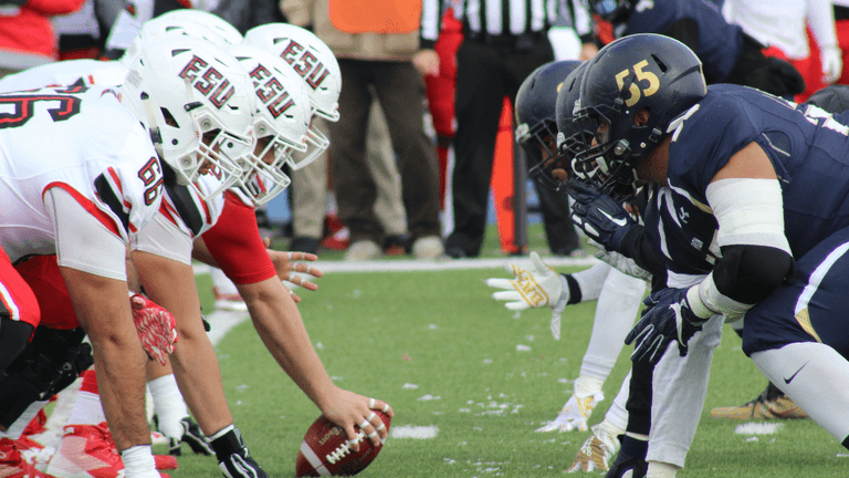 Football teams lined up at the line of scrimmage ready to play